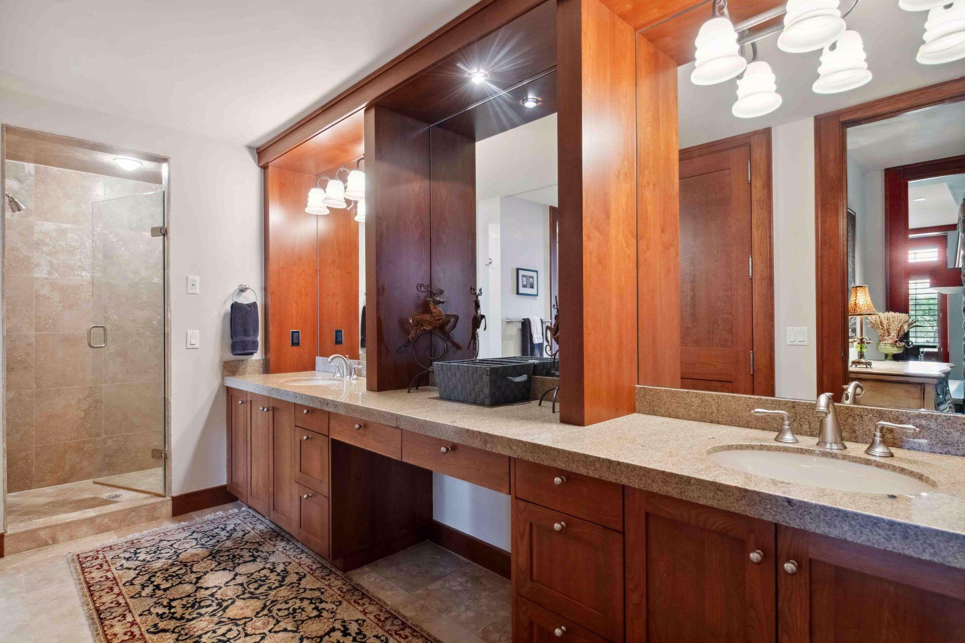 Dual vanity with walk in tile surround shower, separate stool area all part of bedroom one. Lovely tile floors, granite, and custom cherry cabinetry that flows throughout the entire home for consistent quality and craftsmanship