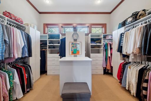 Primary owner suite walk in closet with built-ins and windows to add extra light.