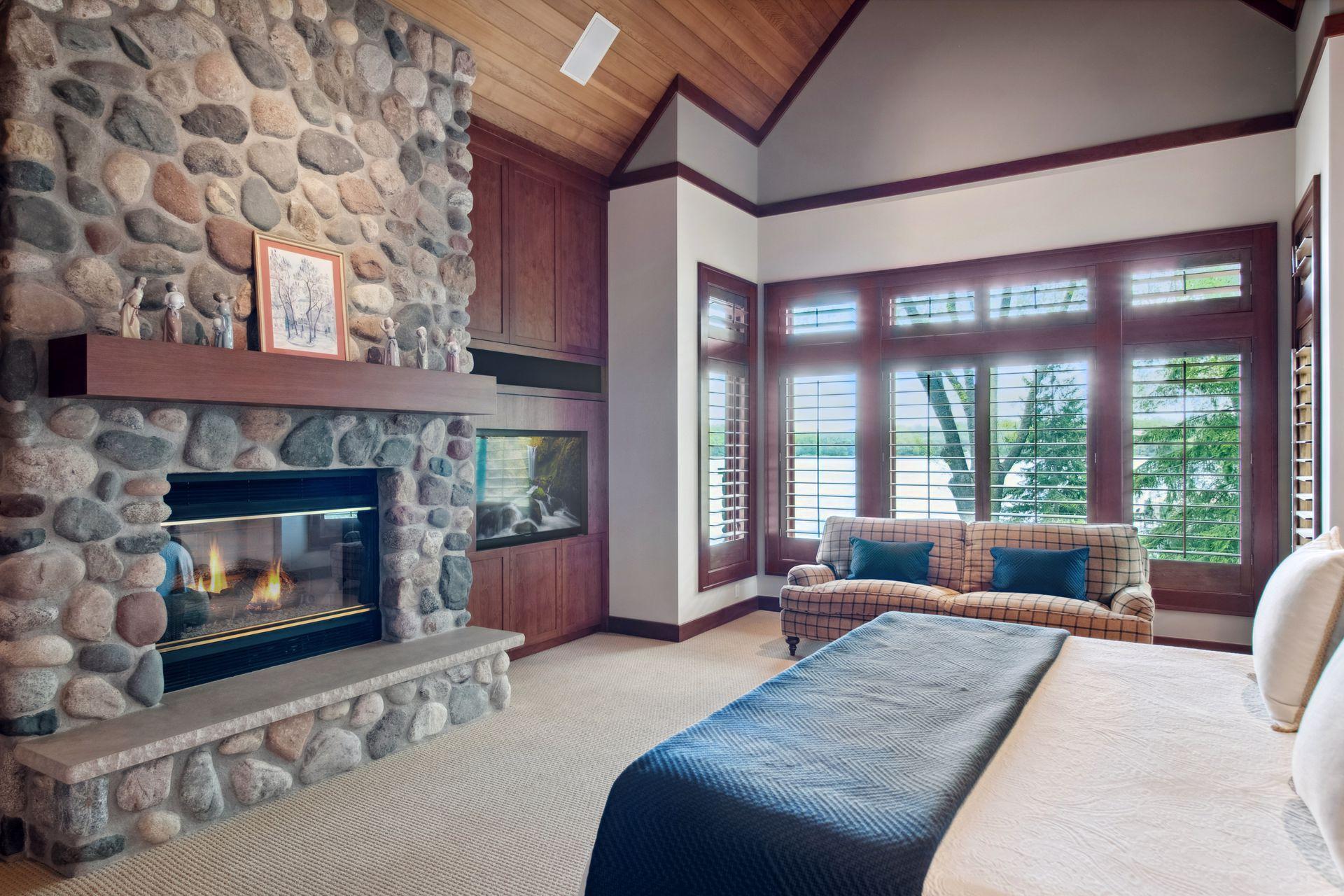 Wall of built-ins and gas fireplace directly adjacent from king bed to enjoy water views year round.