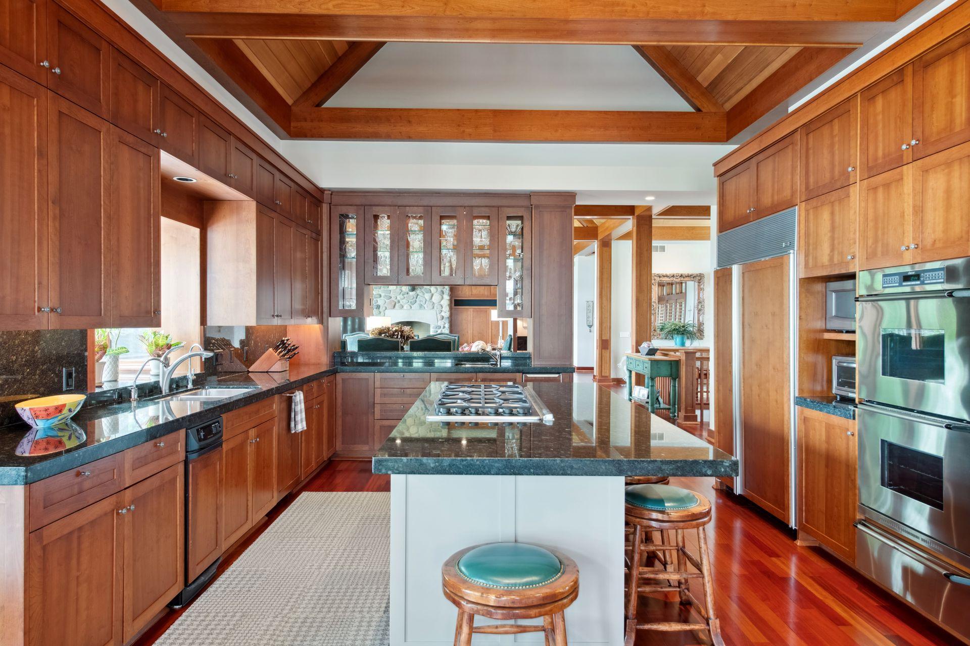 Center island w/gas cooktop, double wall ovens with lower warming drawer, sub zero refrigerator, ice maker, trash compactor, reverse osmosis, and insta-hot faucet all make this kitchen a wonderful space.