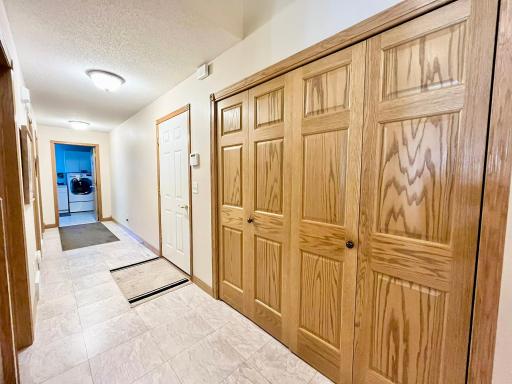 Front hall with large closet, door to garage, pantry, half bath, laundry, and Owners Suite