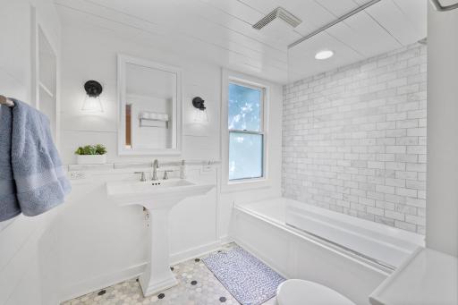 2nd level full bathroom with pedestal sink and freshly enameled wood panelling