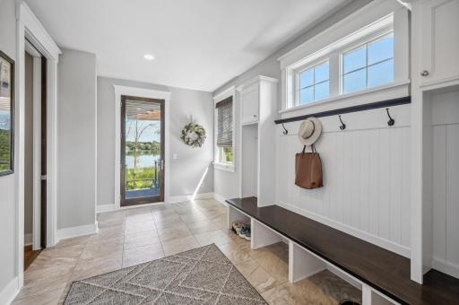 The expansive mudroom serves as the ultimate transition space, seamlessly connecting the garage to the back deck. Designed for both function and organization, it features custom built-in cubbies, ample storage, and durable tile flooring.