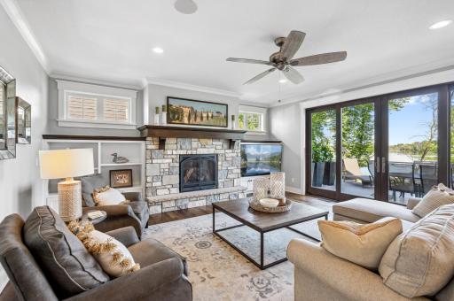 The great room offers expansive views of the lake through a 12 foot wide patio door to the deck with a gas fireplace with stone surround