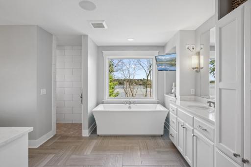 The ensuite bathroom offers the ultimate in comfort with electric heated floors, a tiled shower, and a relaxing soaker tub.