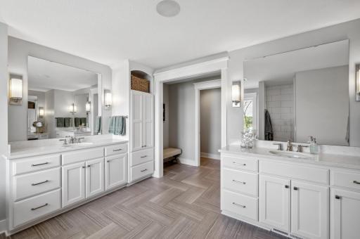 The ensuite bathroom offers dual vanities, providing ample space and style for two. The sleek design is complemented by modern fixtures and elegant countertops, ensuring both function and aesthetics.