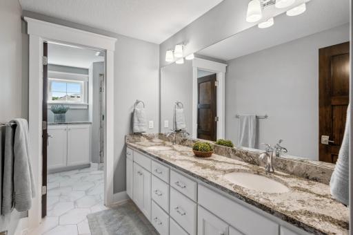 The dual vanity bath offers convenience and style. The spacious vanity provides ample counter space, making it perfect for shared use while maintaining a sleek, organized look.