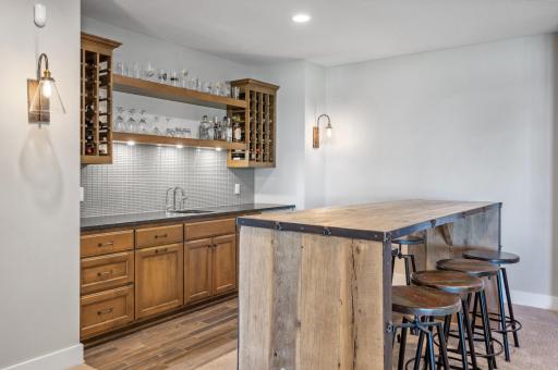 The wet bar is a stylish and functional space, perfect for entertaining. With a sleek Cambria countertop, built-in sink, and wine fridge, itâs designed for mixing drinks and serving guests with ease.