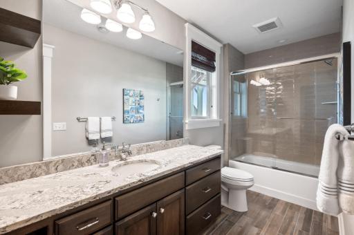 The lower-level full bath is a stylish and functional space, featuring a beautifully tiled shower surround that adds a touch of elegance. The clean lines and modern fixtures create a serene environment.