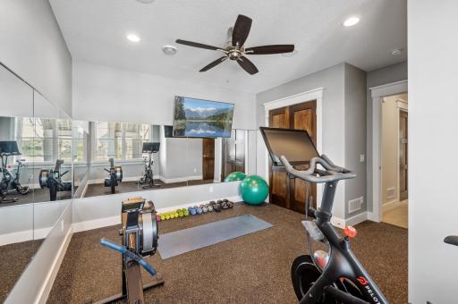 The lower-level exercise room doubles as a versatile space that can easily function as a bedroom. With ample room for workout equipment, its flexible layout allows for a smooth transition into a cozy bedroom.