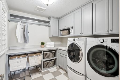The upper-level laundry room is both practical and convenient, featuring a built-in sink for added functionality. This well-organized space makes laundry tasks easy, with ample counter space and storage to keep everything tidy and within reach.
