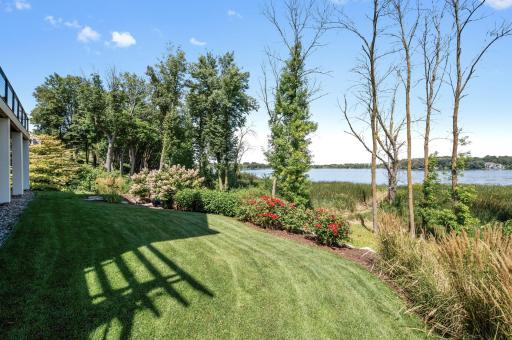 The backyard features thoughtfully designed landscaping, with lush greenery, flowering plants, and well-maintained pathways. The harmonious blend of natural elements creates a peaceful and inviting outdoor retreat