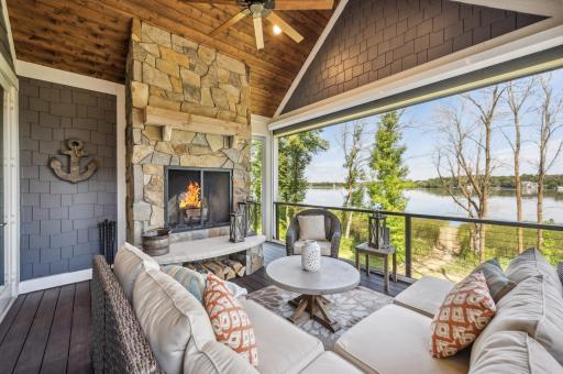 The screen porch offers serene lake views, creating a cozy retreat anchored by a wood-burning fireplace. Perfect for year-round enjoyment, this space invites you to relax and unwind while staying connected to nature.