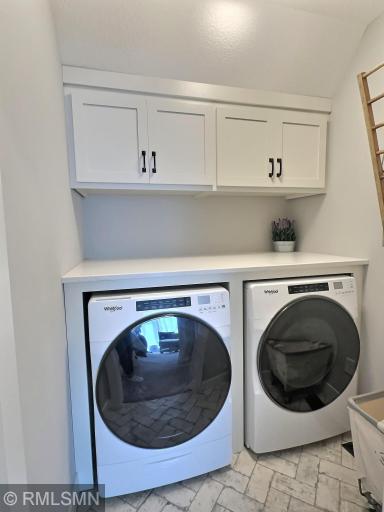 A convenient laundry room is just beyond the entrance of the owner's suite, offering cabinets and a drying rack.