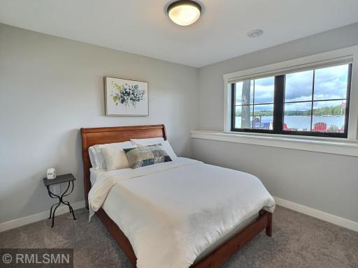 Located in the lower level, the second bedroom offers lake views and closet with custom organization system.
