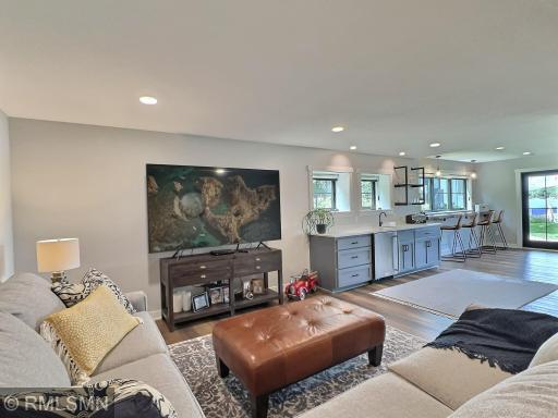 Another view of the lower level, the wet bar is a fun addition with a large counter, cabinets, sink and refrigerator.