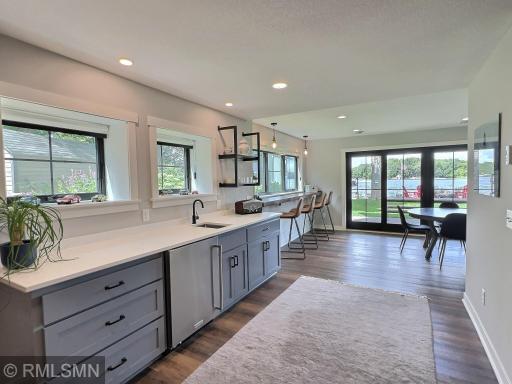 Gather in the walk-out lower level offering a recreation room featuring a wet bar and glass door to lakeside patio.