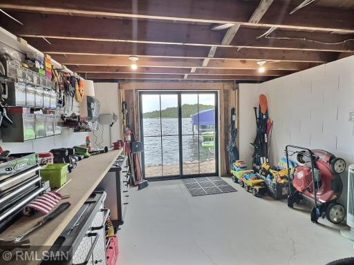 Below the bunkhouse is a lakeside garage space featuring a glass door and storage space.