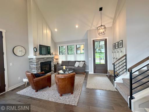 Soaring ceilings lead into the living room glowing from the gas fireplace and natural light from walls of windows.