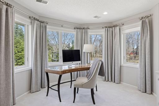Serene and sunlit bedroom office area: bay windows frame backyard views! (Please note curtains are not included)