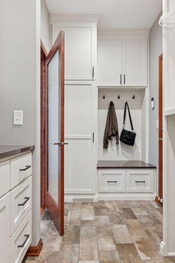 The refreshed bright and functional laundry area features new cabinetry and a striking etched glass door!