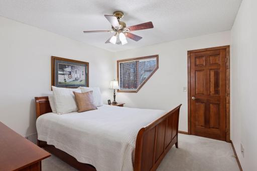 One of three additional bedrooms on the upper level- each with six-panel doors, ceiling fans, and neutral decor!