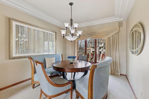 Enjoy memorable occasions in the stylish dining room featuring tray ceilings, and elegant window coverings!