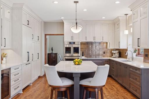 Completely remodeled modern and elegant kitchen with quartz counters, soft-close drawers, neutral cabinets, and a striking copper backsplash!