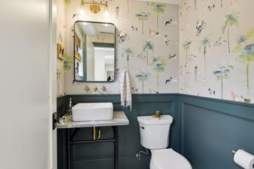 Main floor powder bath with adorably whimsical wallpaper!