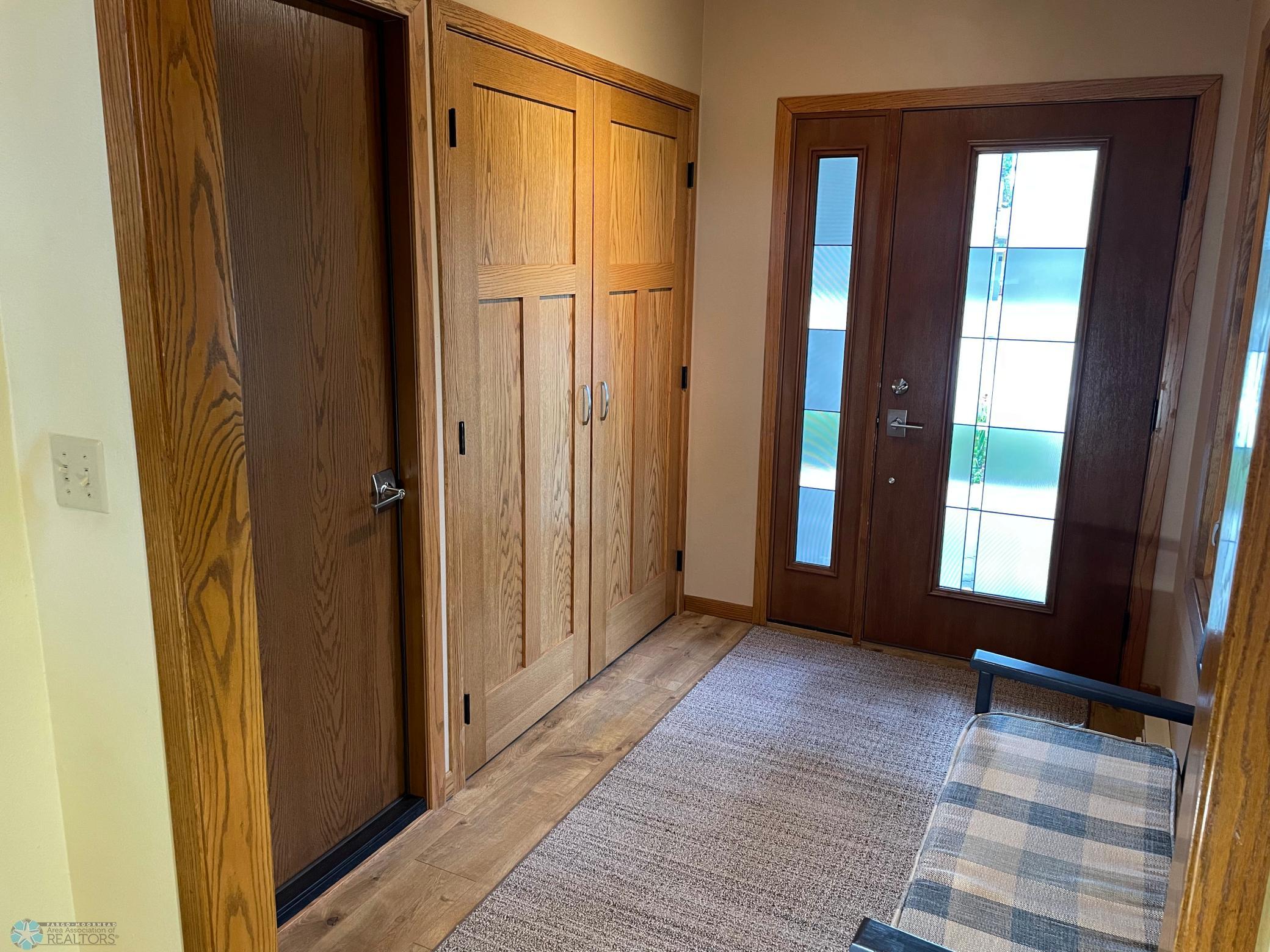 Large foyer with big entry closet, garage entry door, and updated decorative front door with sidelight.jpg