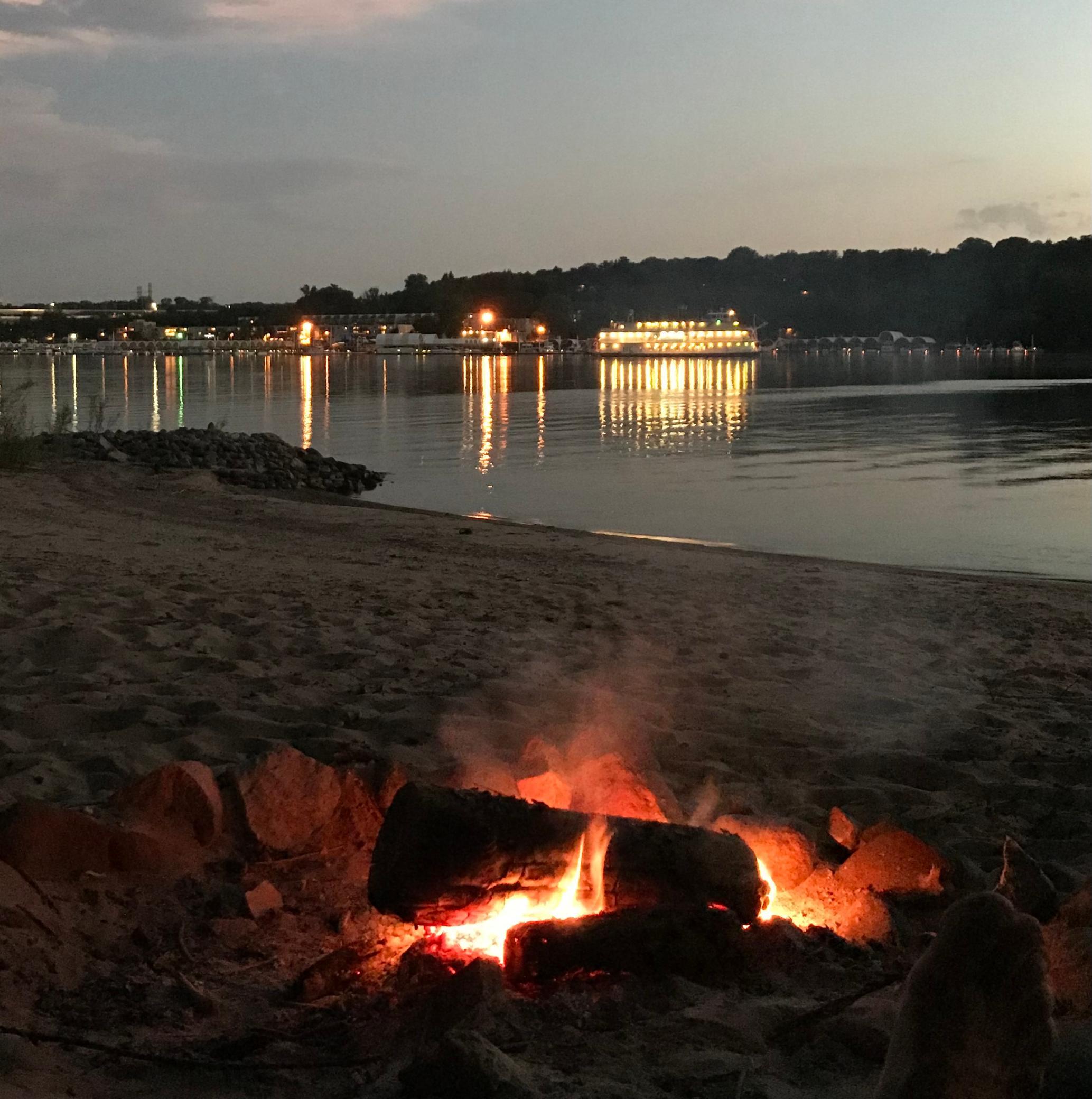A backdrop of riverboats pass by as you enjoy your bonfire