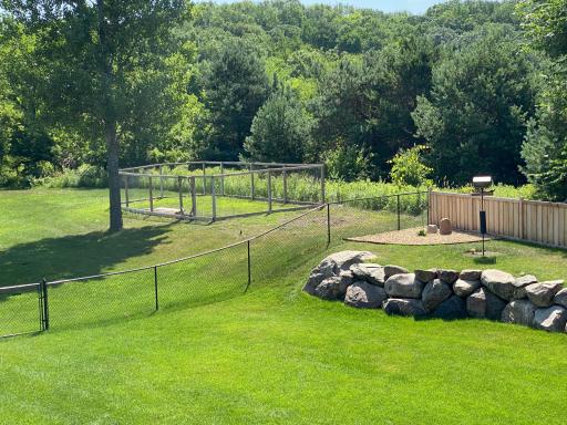 The Back Yard is Entirely Fenced, Including 195 Feet of 4 ft Privacy Fence Above the Boulder Wall. Here 1 of 3 Gates, at Left, Leads Out to a 36 x 17 ft Garden (Also Organic) with a 70-Inch Tall Fence.