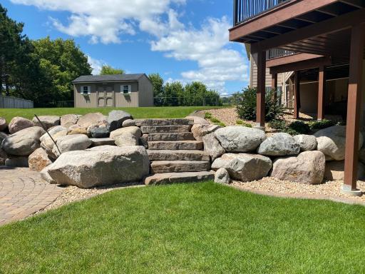 Extensive Boulder Landscaping and Stairs Here Lead to the Upper Tier of the Back Yard.