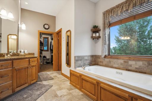 The Owner's Suite Full Luxury Bath with Tall Dual Vanities and Cabinets, Travertine Tile Floor, Oversized Jetted Tub, a Large Window (but Privacy with the Elevation), a Separate Toilet Room a Walk In Closet...