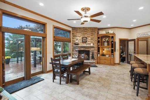 The Natural Flow Leads to this Spacious Formal, or Informal, Dining Area and a 2nd Fireplace. Notice More Transom Windows, the Elegant Porcelain Tile Flooring and Crown Molding Extending into the Kitchen, and More Scenic Views from Here or the Deck.