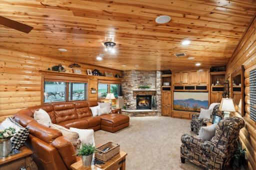 The Lower Level Family Room Fully Embraces a Lodge Theme with Knotty Pine Log Siding on the Walls to Compliment the Pine Ceilings. And of Course, More Big Windows! Note that the 75-Inch Big Screen TV, Unique to it's Space, is Included with the Sale.