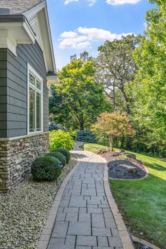Decorative paver front walk carefully meanders around the landscape