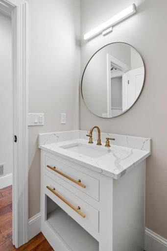 1/2 Bath features furniture like vanity with quartz top & rustic maple hardwood flooring
