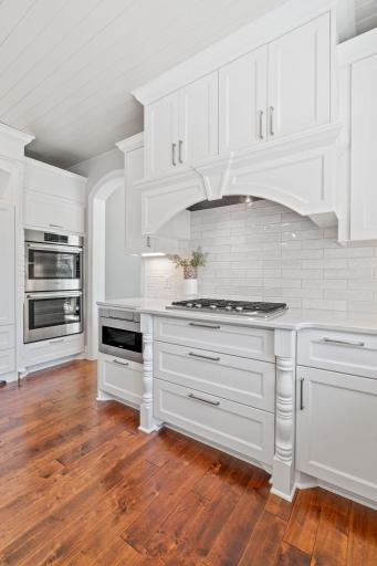 Appliances include KitchenAid gas cooktop w/ decorative paneled hood, Bosch dual wall ovens , Bosch refrigerator, Bosch cabinet paneled dishwasher, beverage refrigerator, Sharp built-in microwave