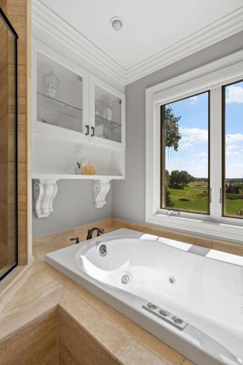 Jetted tub situated on a tile deck and surround