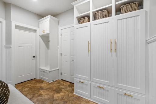 Mudroom features built-in lockers w/ bead-board paneled doors and open cubby storage, tile flooring and large walk-in closet with custom organizer (not pictured)