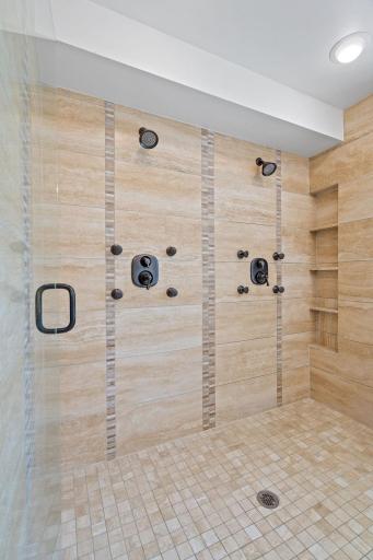 Oversized shower offers modern tile surround, dual all over body jet and shower
head systems, shampoo niche and semi-frameless glass enclosure