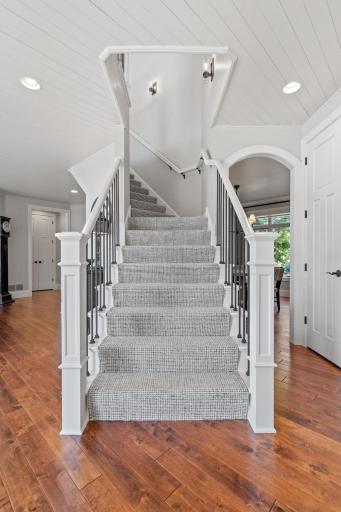 Staircase to the Upper Level - open w/ wool carpet runner, decorative wall sconces, painted box newel posts, railings and iron accents