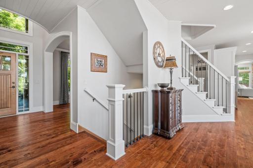 Staircases are open w/ wool carpet runner, decorative wall sconces, painted box newel posts, railings and iron accents