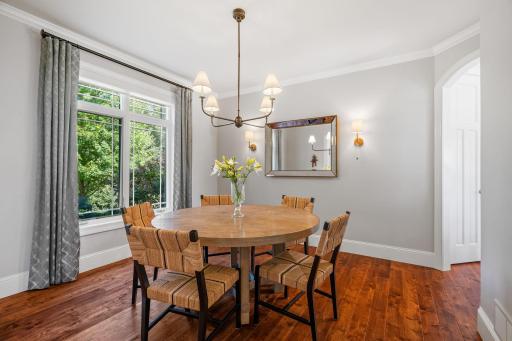 Dining Room features arched openings, crown molding, pair of decorative sconces and rustic maple hardwood flooring