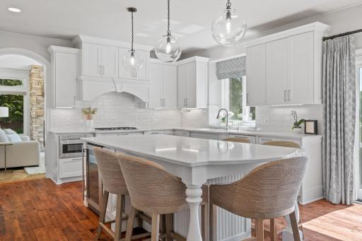 Custom enameled cabinetry features flat paneled doors, roll-out interior storage, under cabinet accent lighting, full height pantries, open display w/ lighting, oversized âeat-inâ center island, bead-board and furniture like details