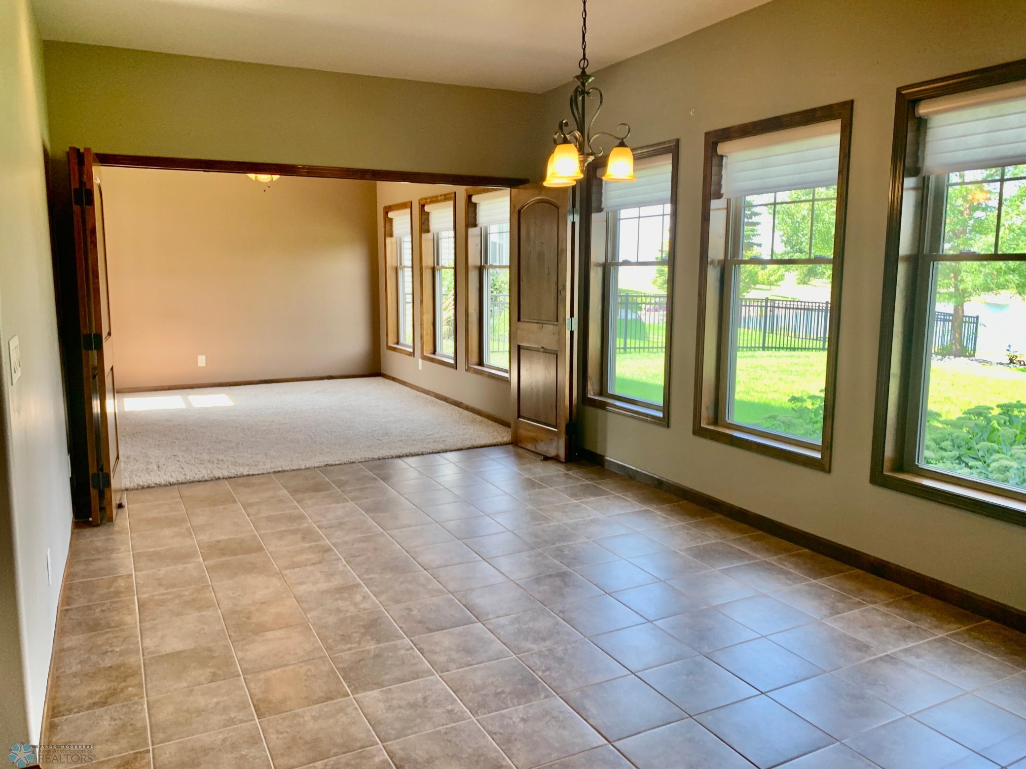 View from dining room into what could be the 2nd primary suite separated by folding doors.