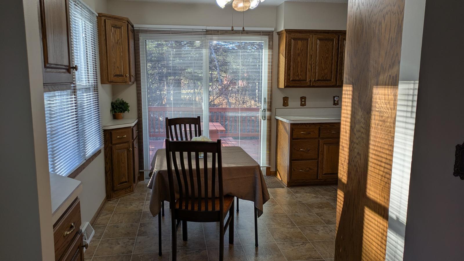 Dining area looking out to large deck off side of house and windows to the front creates lots of natural light with the front southern exposure!