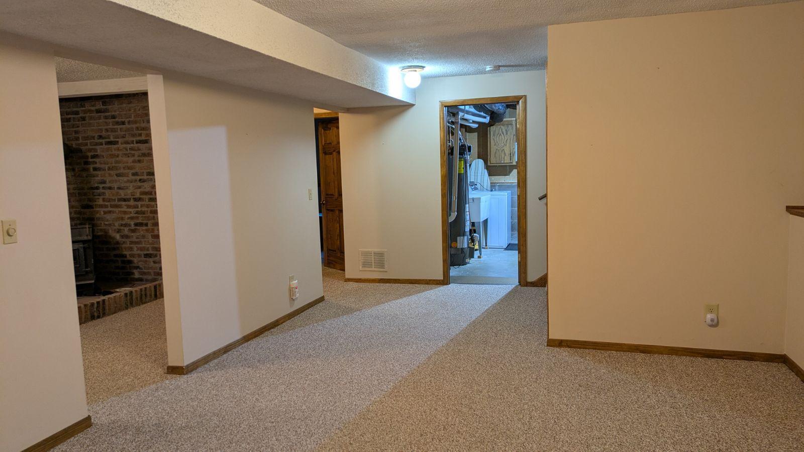 View from Family Room to utility/laundry room, Amusement room, bedroom, bathroom, and stairs. Great place to have a toy room, game area, library or office even!