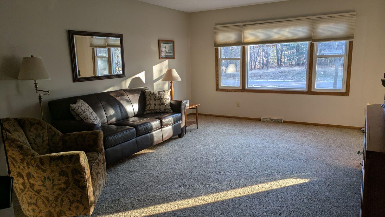 Spacious living room with view of woods out front window